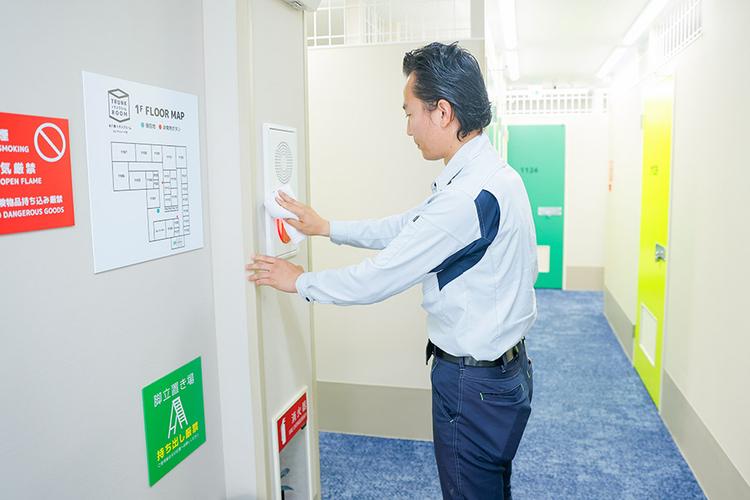 非常用ボタンを清掃するスタッフ