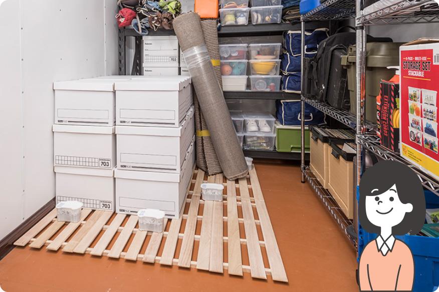 収納スペースに棚やパレットを設置し、湿気や害虫対策をしている様子