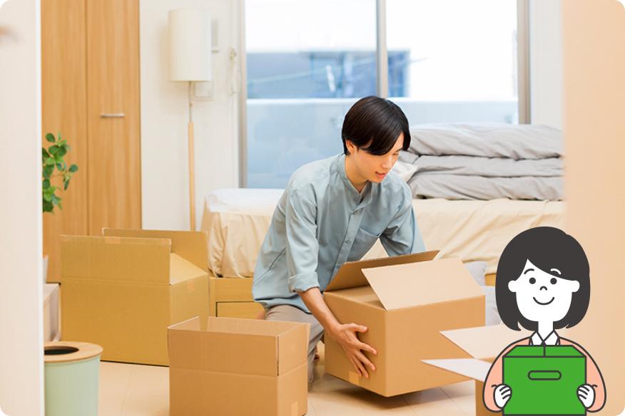 男性が室内で複数のダンボールに荷詰めしている様子