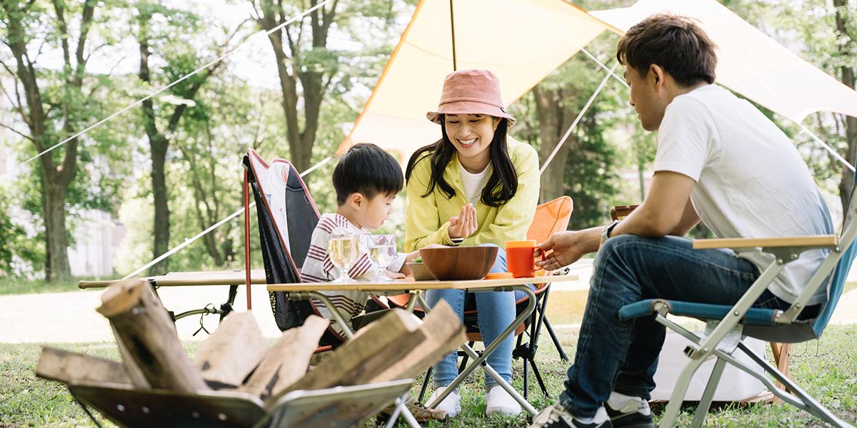 親子三人でアウトドアを楽しんでいる写真